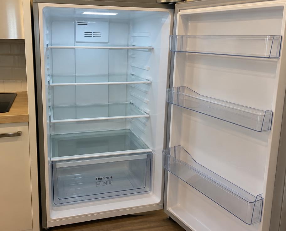 Clean, empty fridge with glass shelves and door compartments
