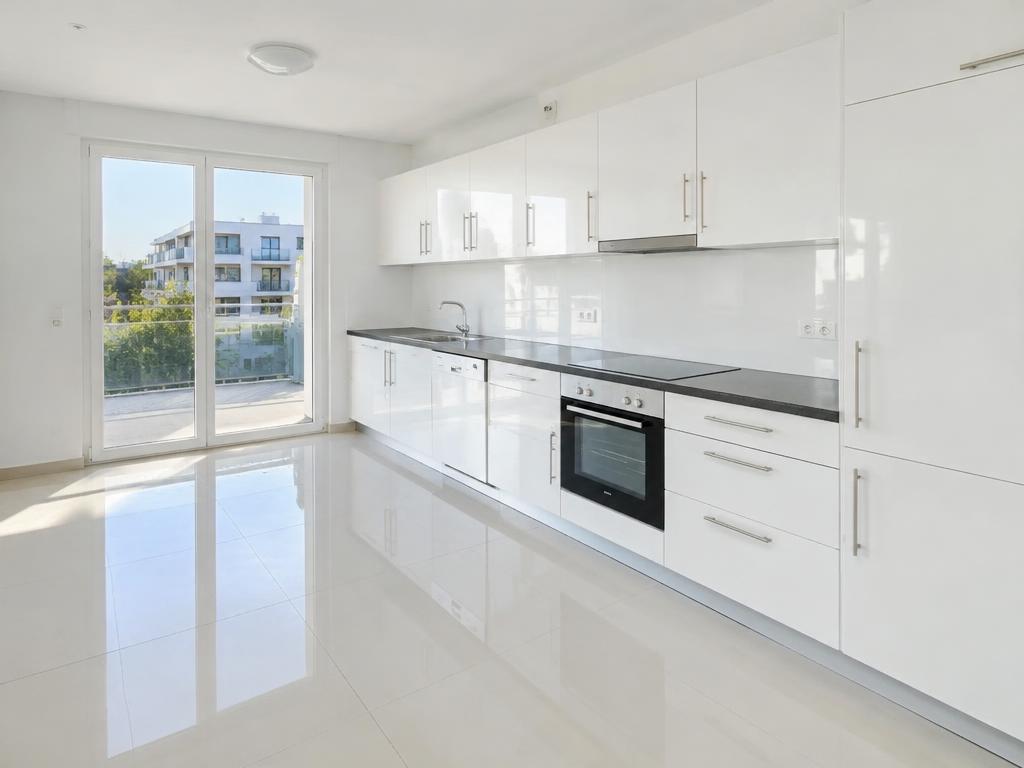 Empty, spotless rental kitchen with glossy white cupboards ready for handover
